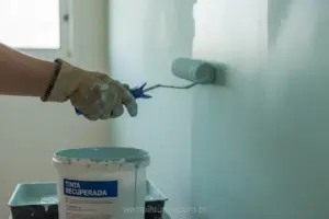 Pintor profissional utilizando tinta recuperada em parede interna.