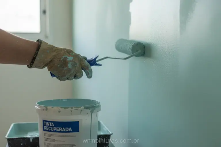Pintor profissional utilizando tinta recuperada em parede interna.